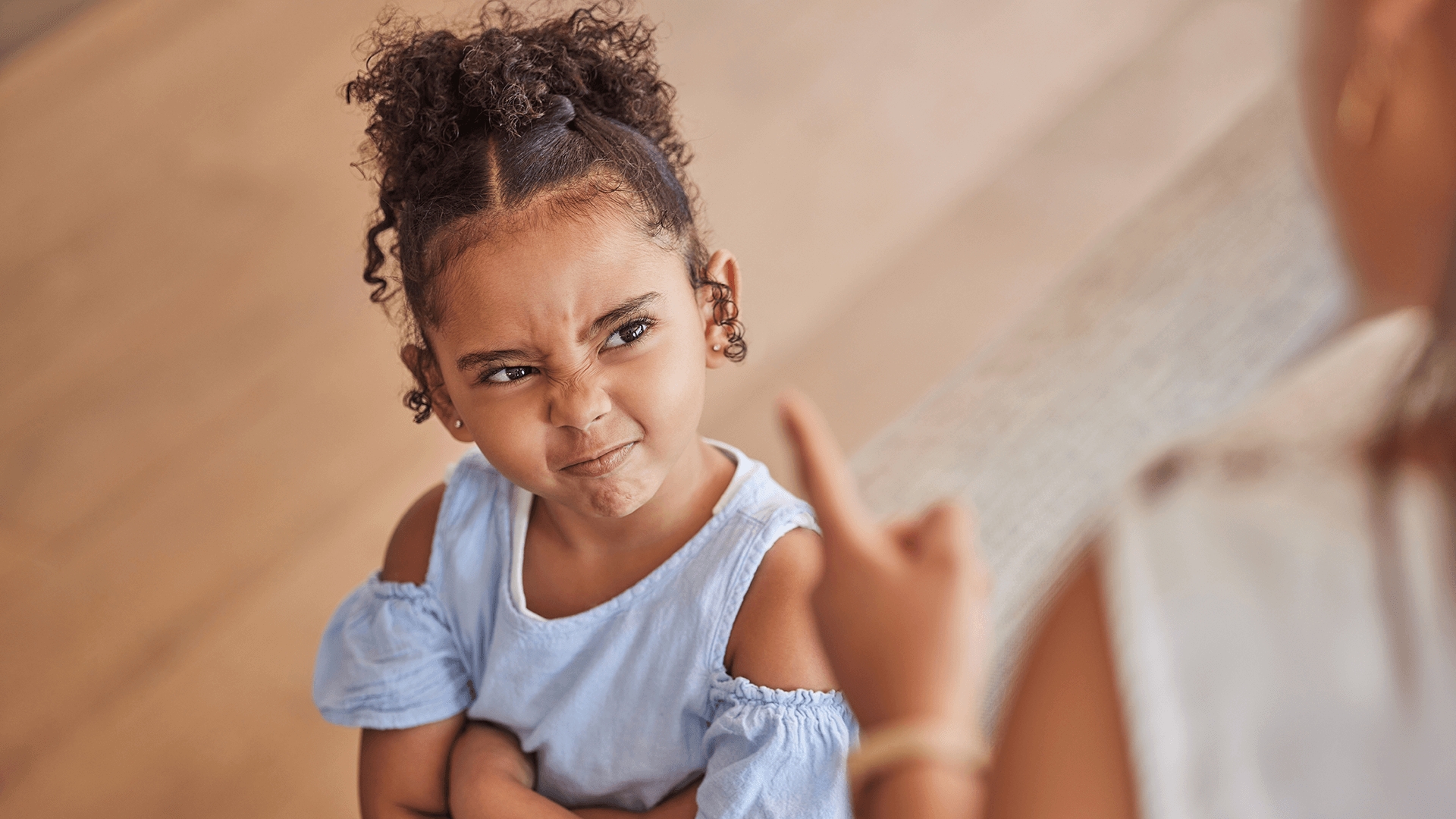 Young girl with smirk on face looking at parent