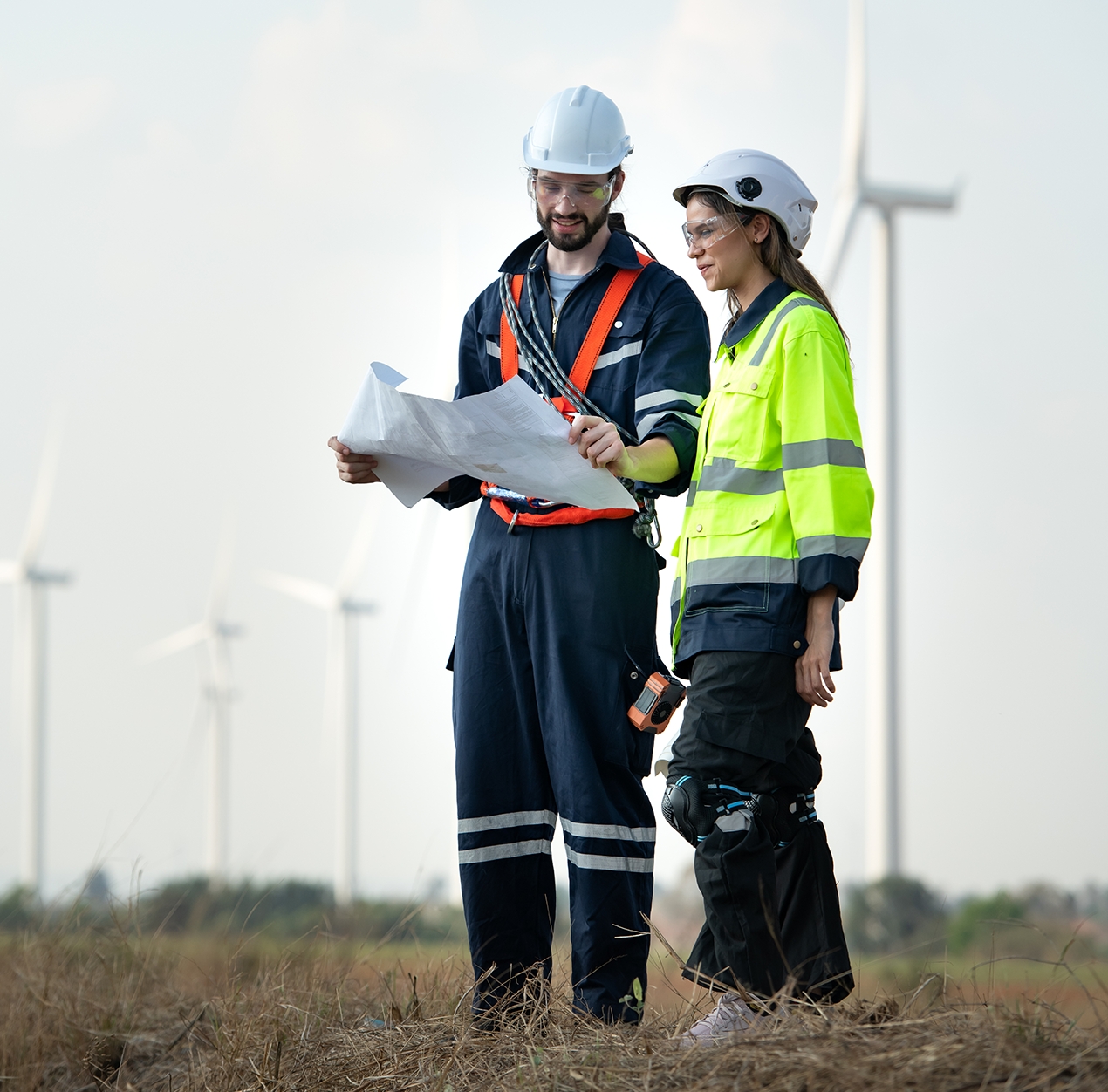 Man and female engineer stationed at the Natural Energy Wind Turbine site. with daily audit tasks of major wind turbine operations that transform wind energy into electrical electricity