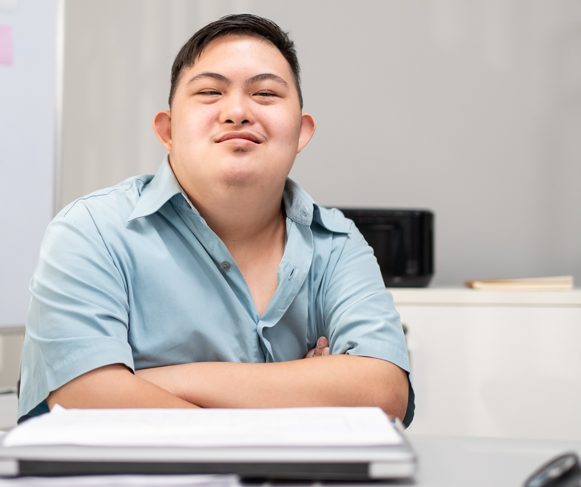 Portrait of Asian young businessman patient work in office workplace. Attractive male employee worker people with down syndrome smiling and looking at camera in company. Corporate of modern colleague.