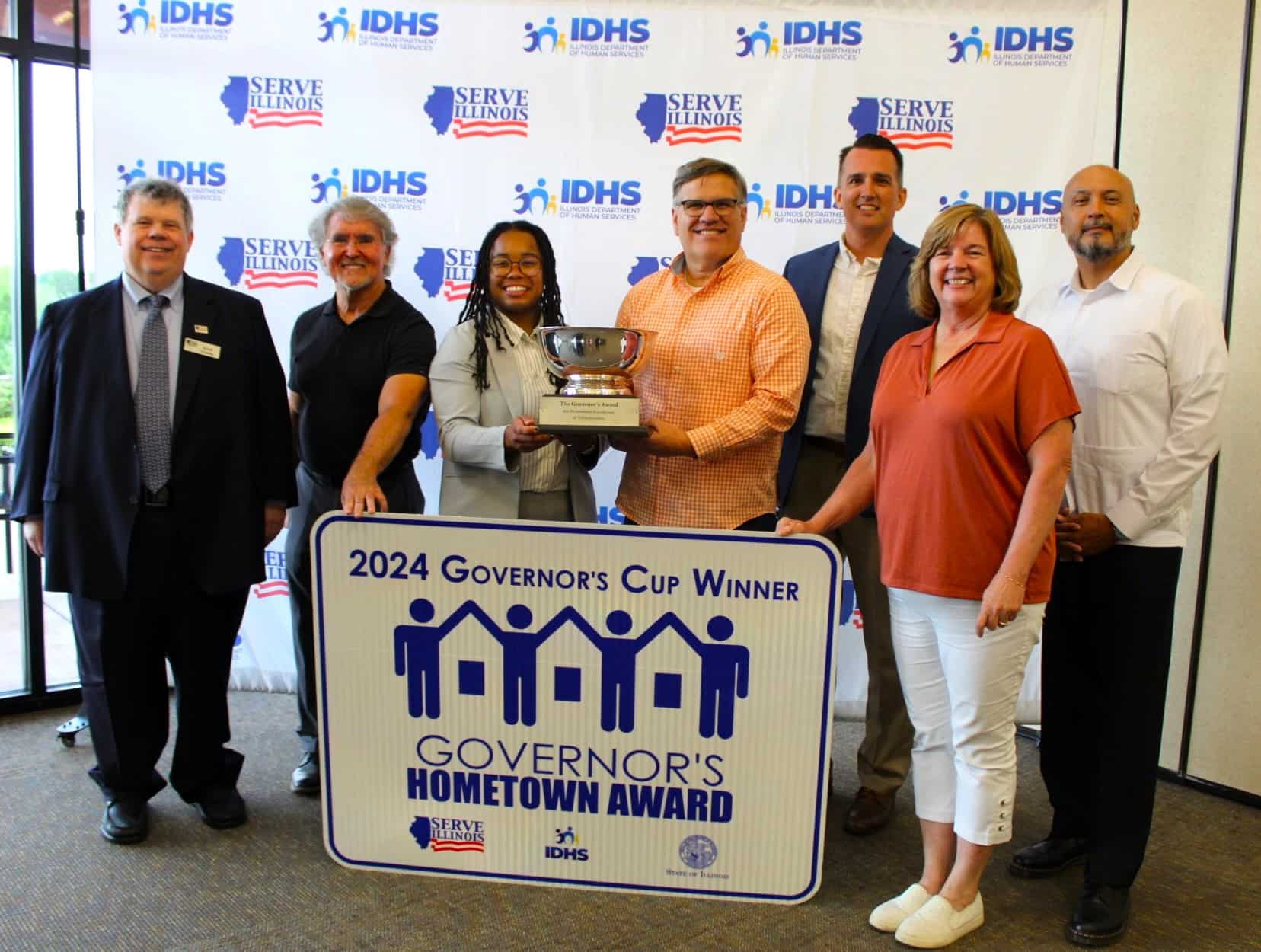 Challenger Baseball representatives holding Governor's Cup with highway sign