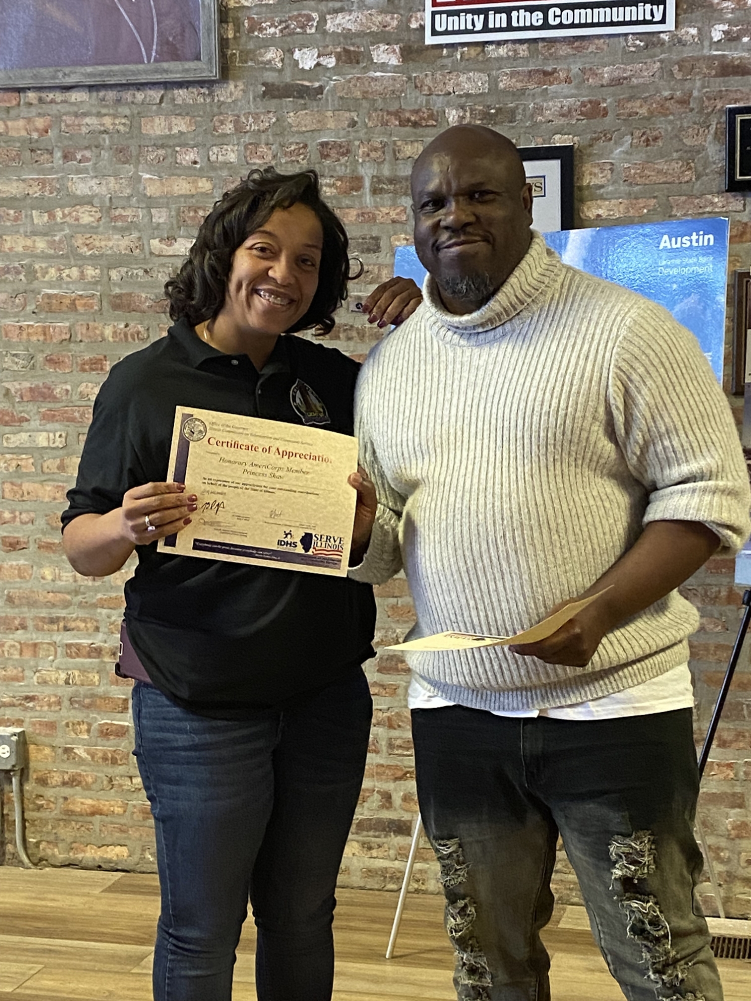 Princess Shaw on left holding Governor's Certificate of Appreciation and on the right Serve Illinois Volunteer Program Manager Jacob Jenkins