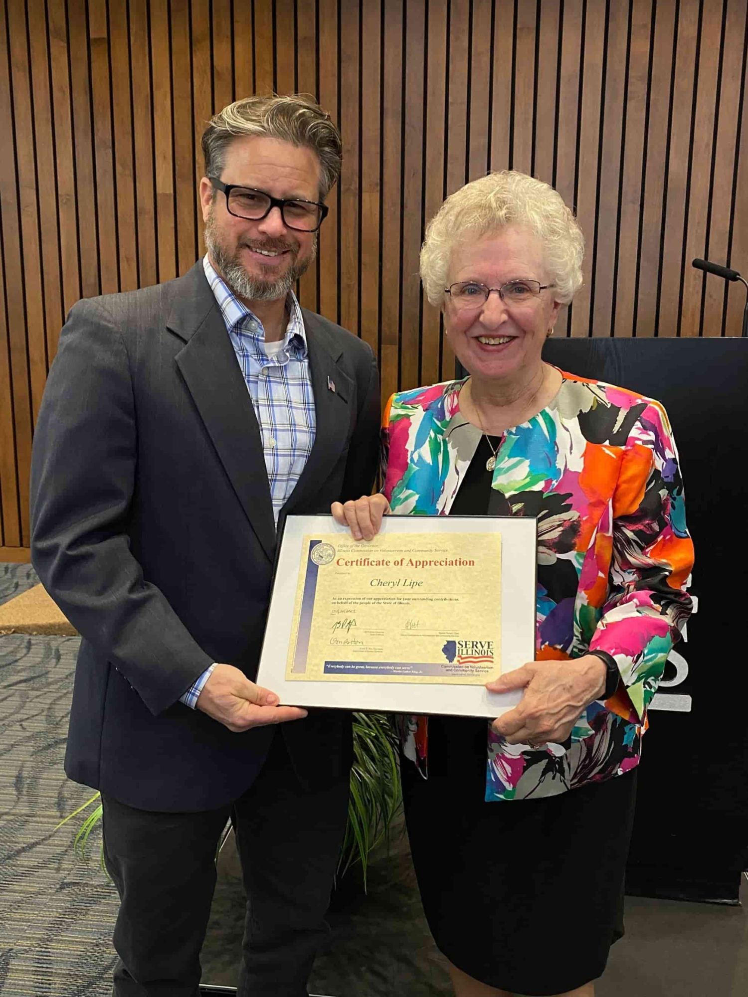 Good as gold ceremony awardee holding governor's certificate with staff member Anthony Wanless