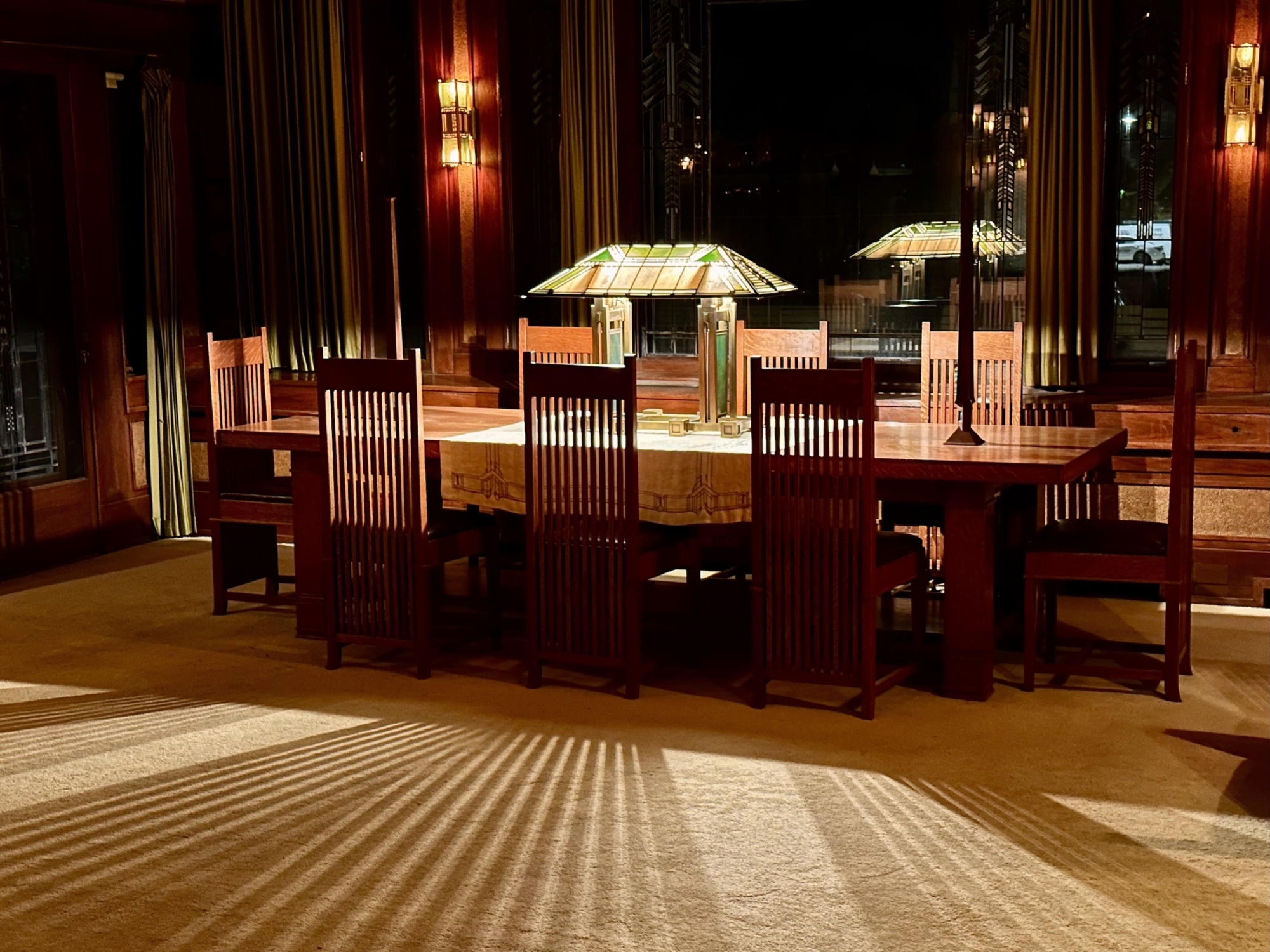 glass lamp on table surrounded by chairs, in the evening