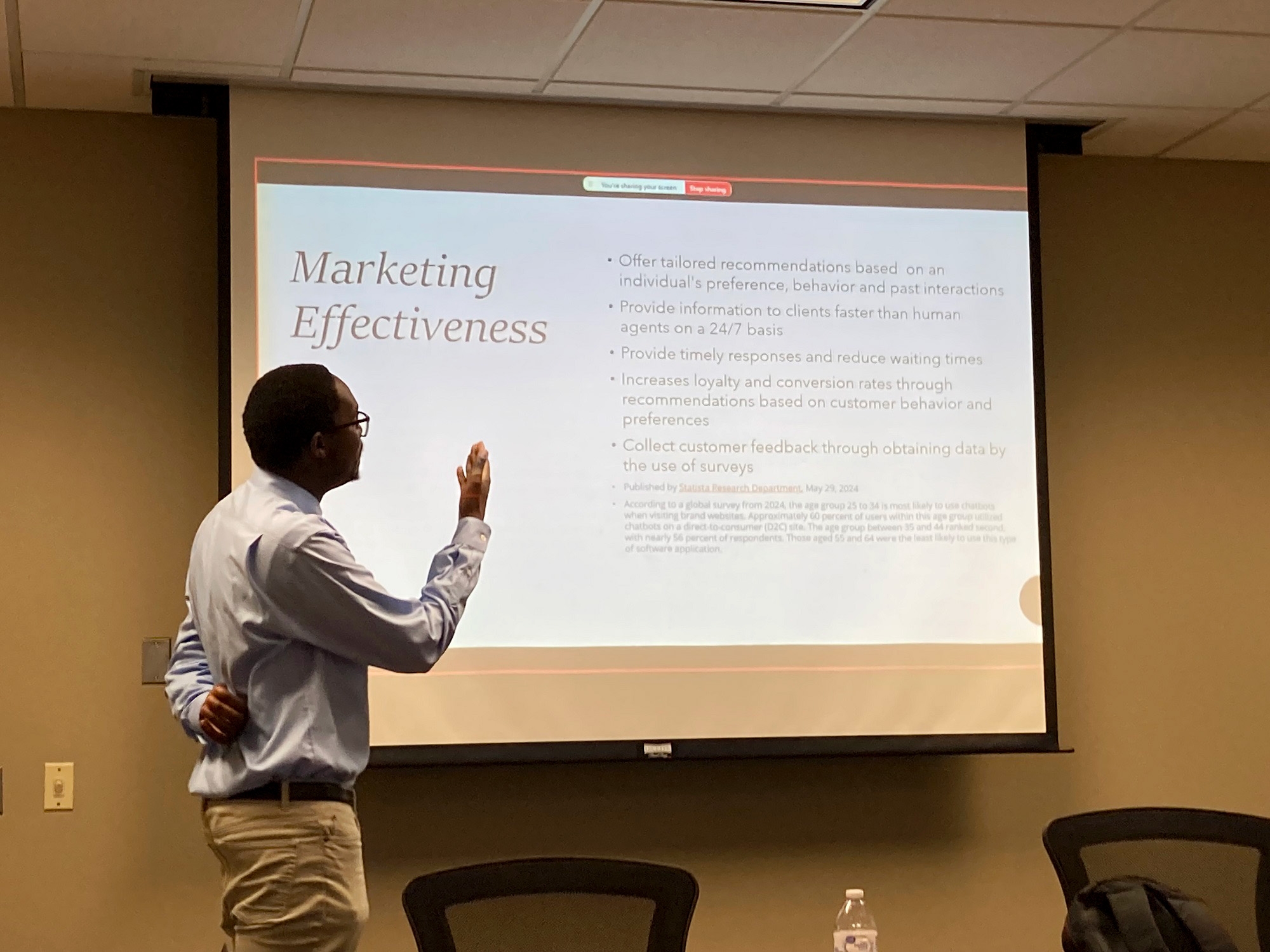 man standing in front of presentation talking