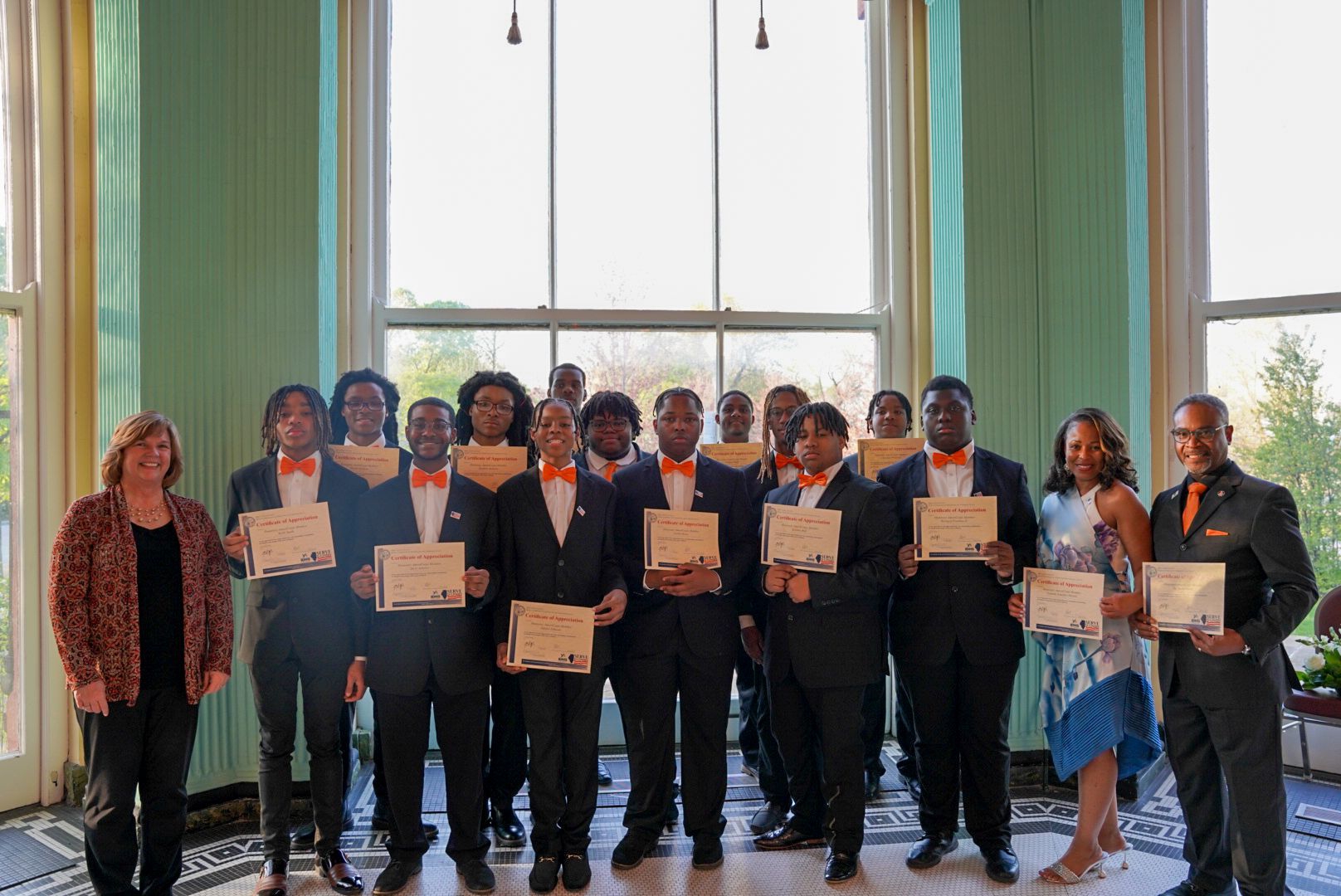 Commissioner Amy Rueff with Leo High School boys' choir, Leo High School Principal, Dr. Shaka Rawls, Choir Director LaDonna Hill, Coordinator Yolanda Sandifer-Horon with governor's certificates of appreciation and honorary AmeriCorps member pins