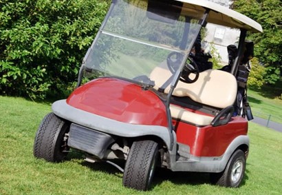 generic red golf cart parked in the grass 