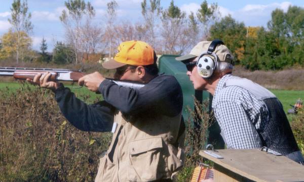 Instructor with student shooting a shotgun at target