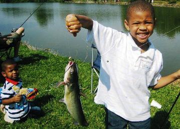 boy showing off his catfish he caught.