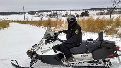 Conservation Officer on a modern snowmobile