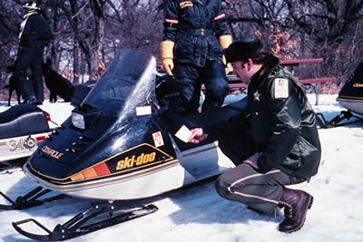Conservation Police inspecting a snowmobile in the 80's