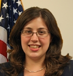 Fallon Opperman standing in front of an American flag.