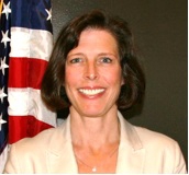 Susan Haling standing in front of the American flag.