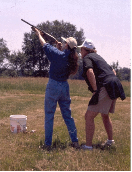 Instructor with student shooting a shotgun at clays