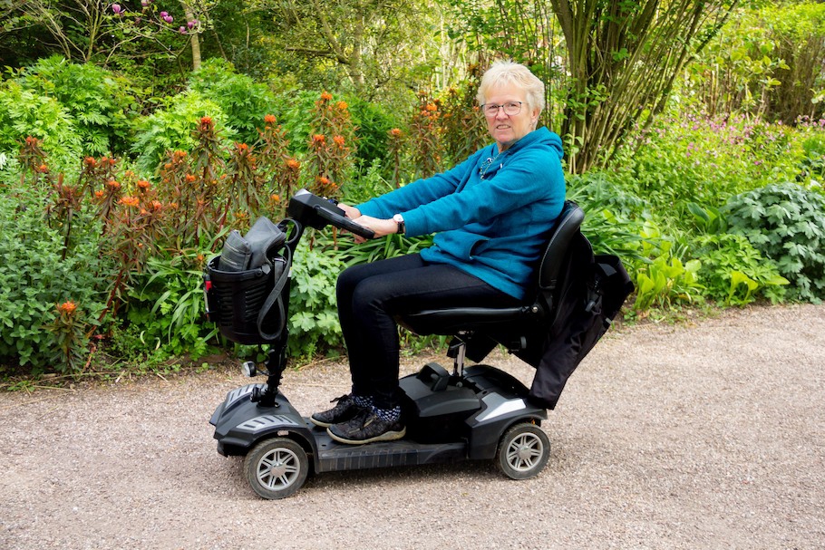 Woman on mobility scooter enjoying freedom of being outdoors on a spring day