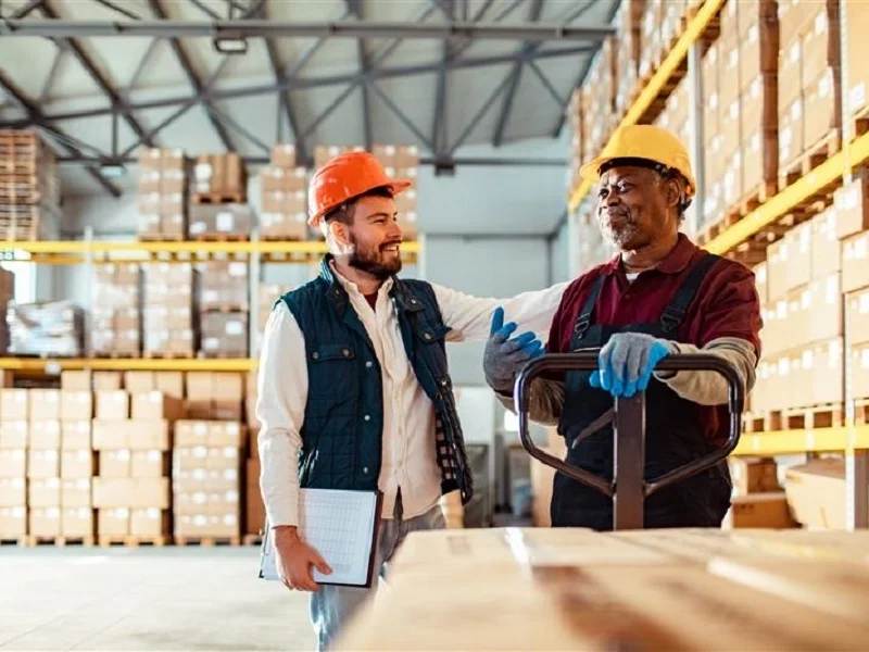 A team of two professionals in conversation in a warehouse