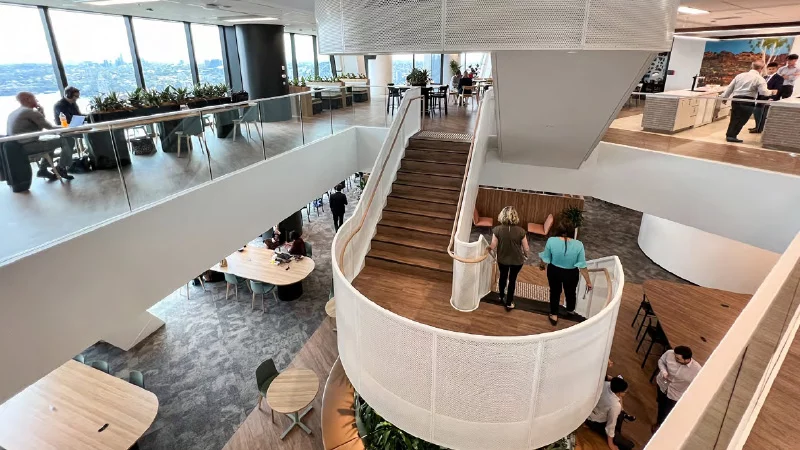 Escadaria dentro de ambiente de escritório, com duas mulheres descendo
