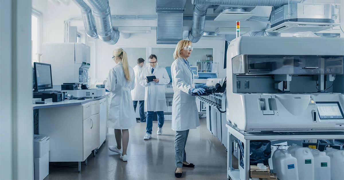 Group of engineers in white coats working in the laboratory of a pharmaceutical company