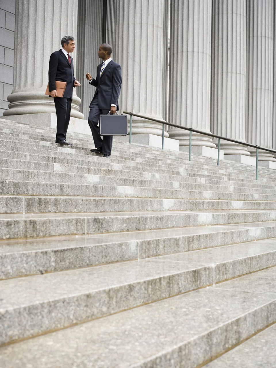 Low angle view of two men standing on the steps of a courthouse