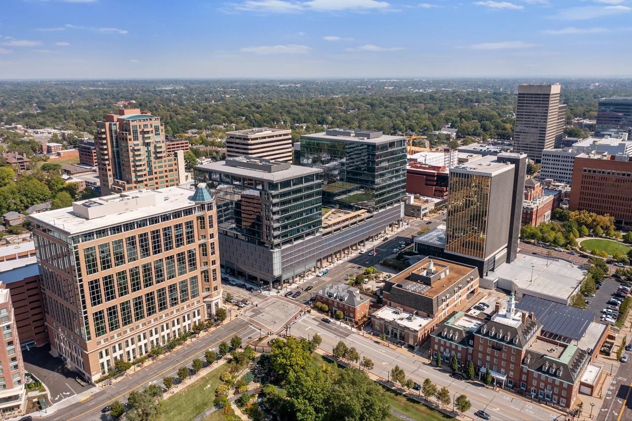 Aerial view of office building exterior along city street on a sunny day.