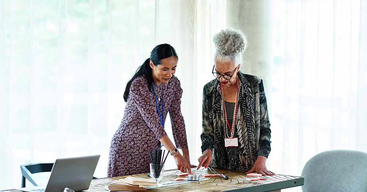 Two Businesswomen brainstorming in an office using adhesive notes before the meeting