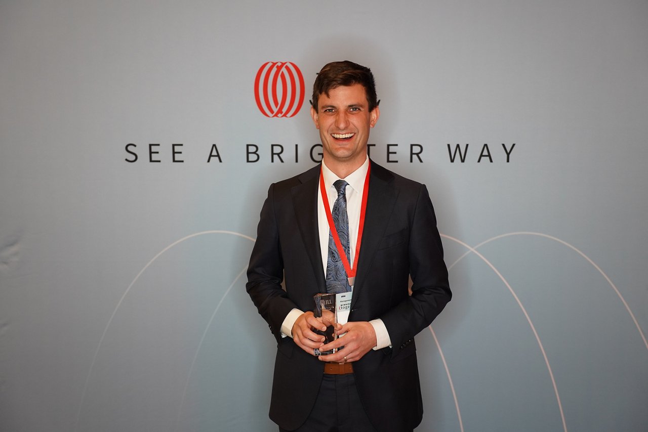 Miguel holding an award