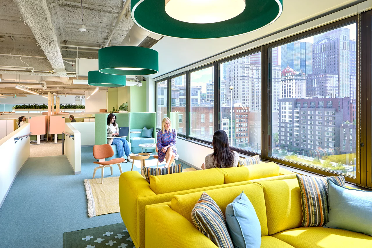 Modern office lounge space featuring a bright yellow sofa