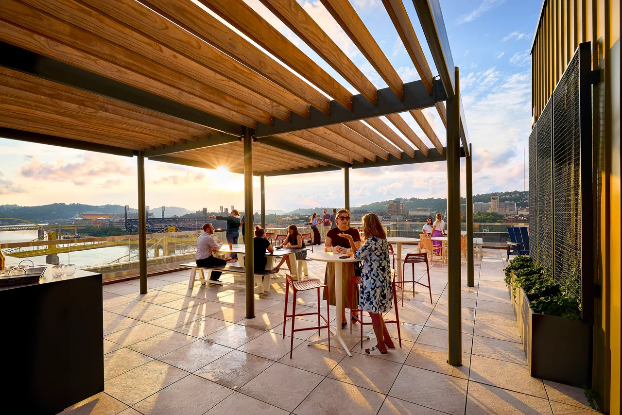 A modern rooftop terrace with wooden pergola providing partial shade
