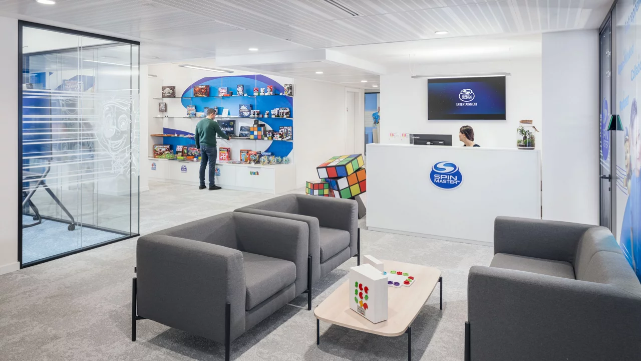 Lobby featuring a large blue wall and a prominent television screen, creating a modern and inviting atmosphere.