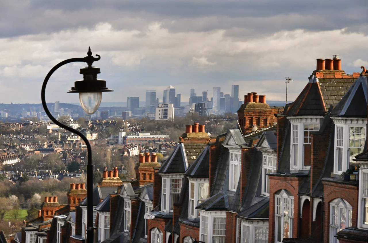 Beautiful period red brick home rooftops in a London suburban hill terrace overlooking the distant view of downtown  financial district offices. London, UK