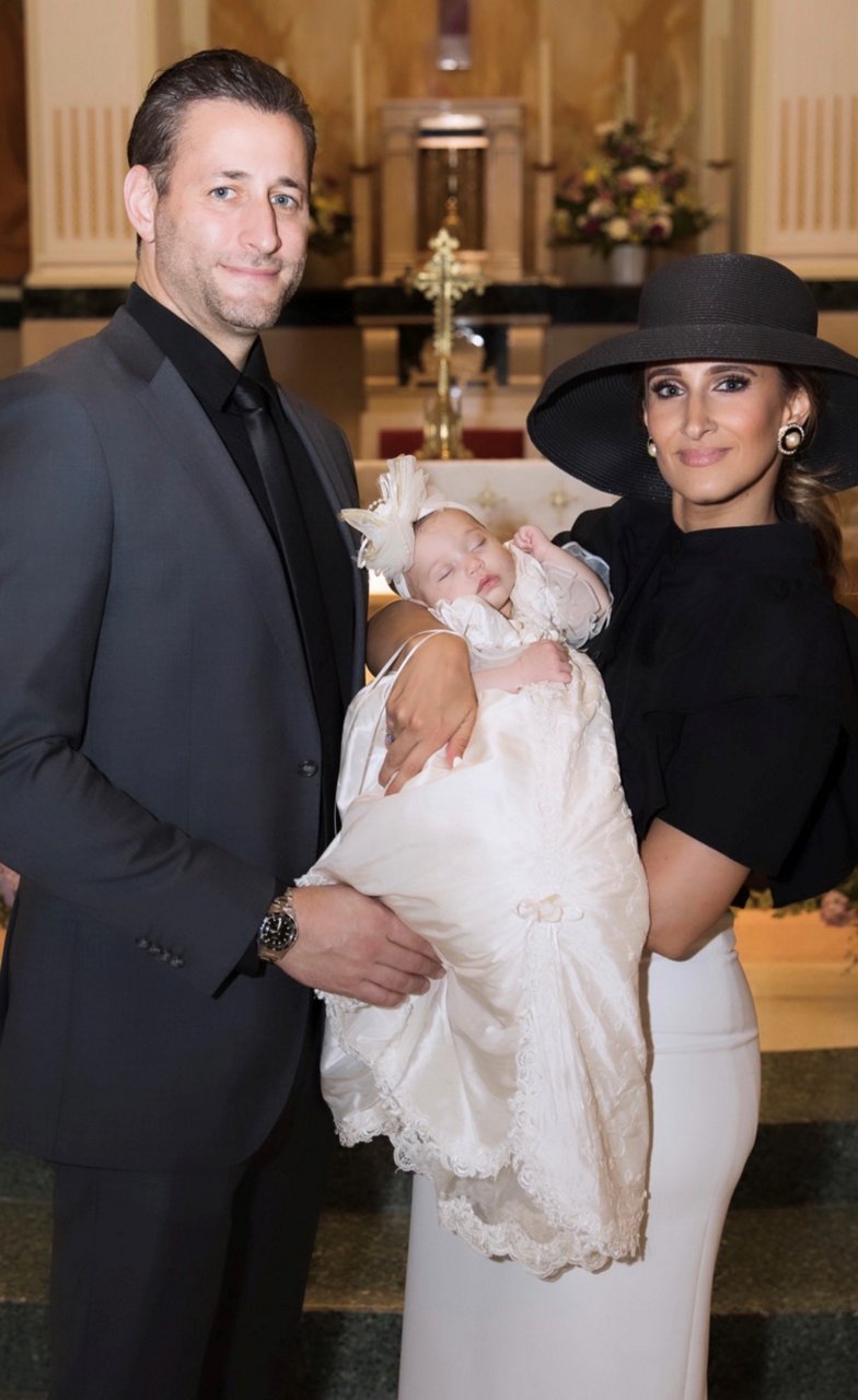 a couple holding their a year old child.