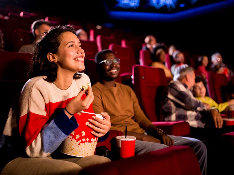  A woman sits in a theater with popcorn