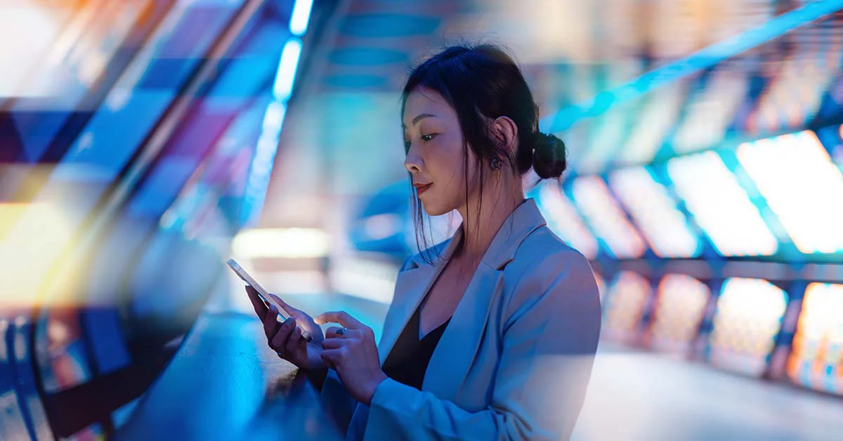 A professional woman in a business suit is using her smartphone