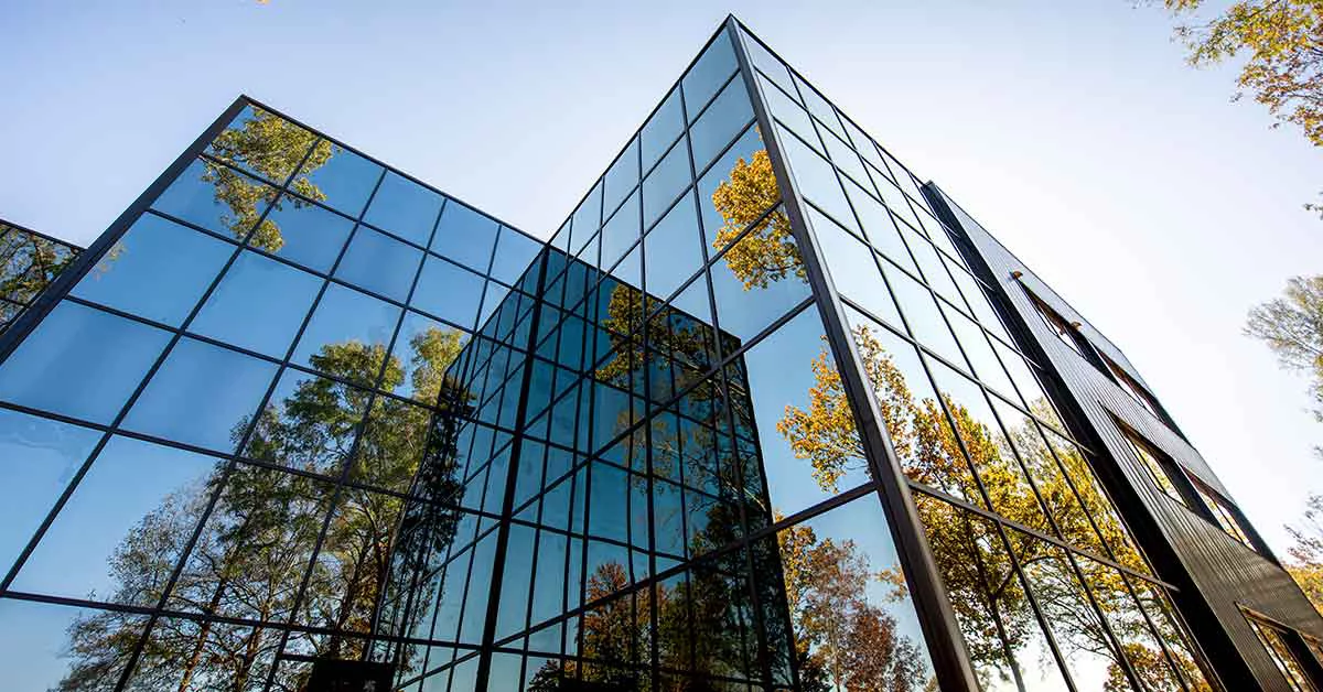 Modern building with windows reflecting trees