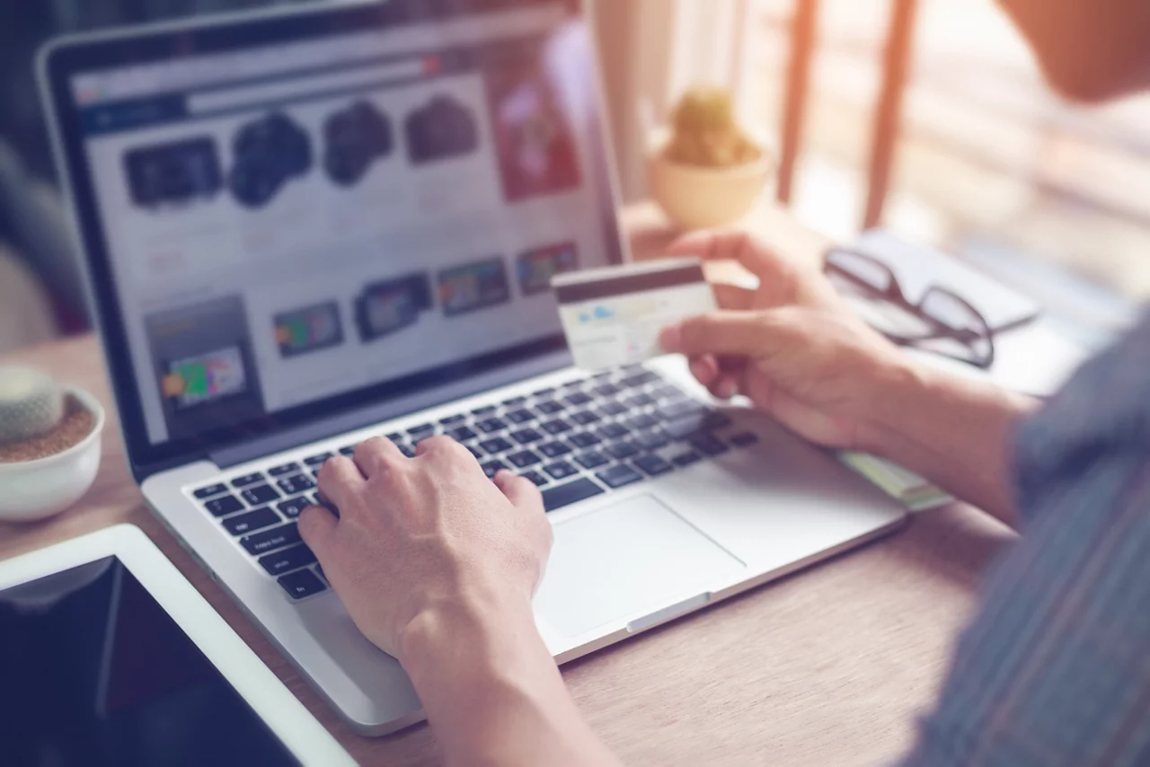 Man's hand using laptop computer for online shopping with credit card