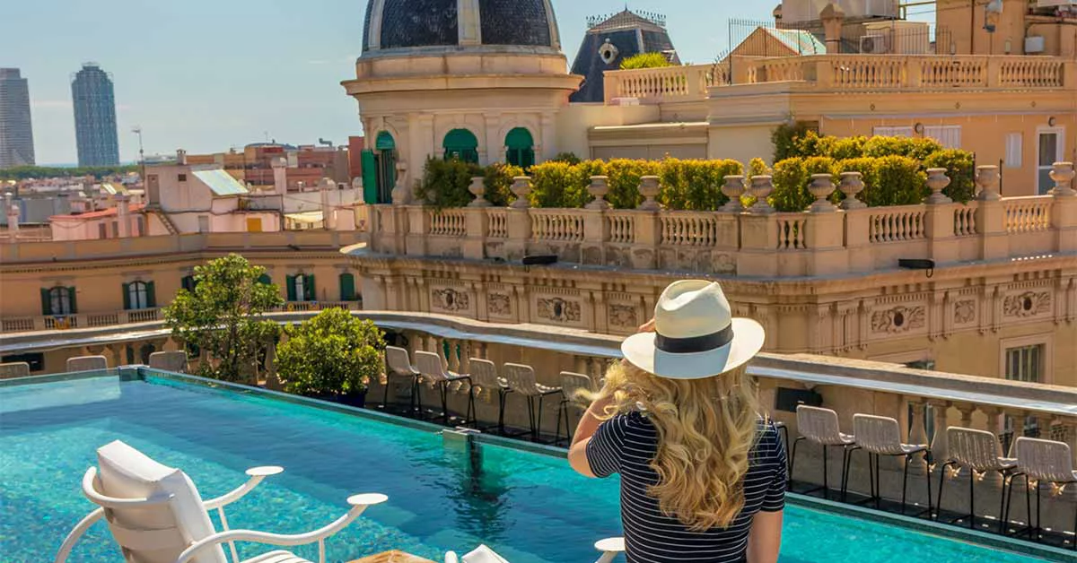 A woman in a hat gazes out over the hotel pool