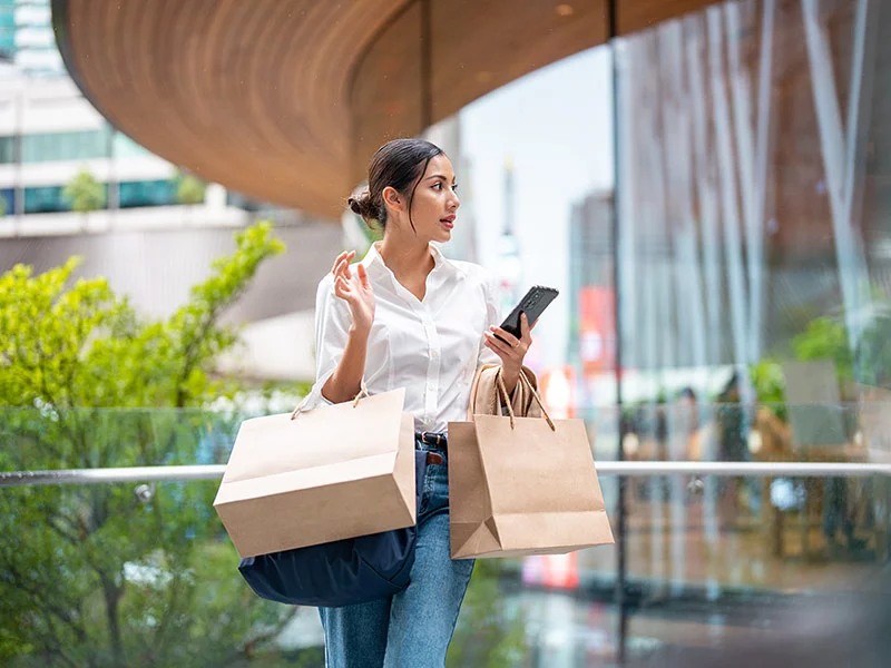 Women with bag and mobile on other hand 