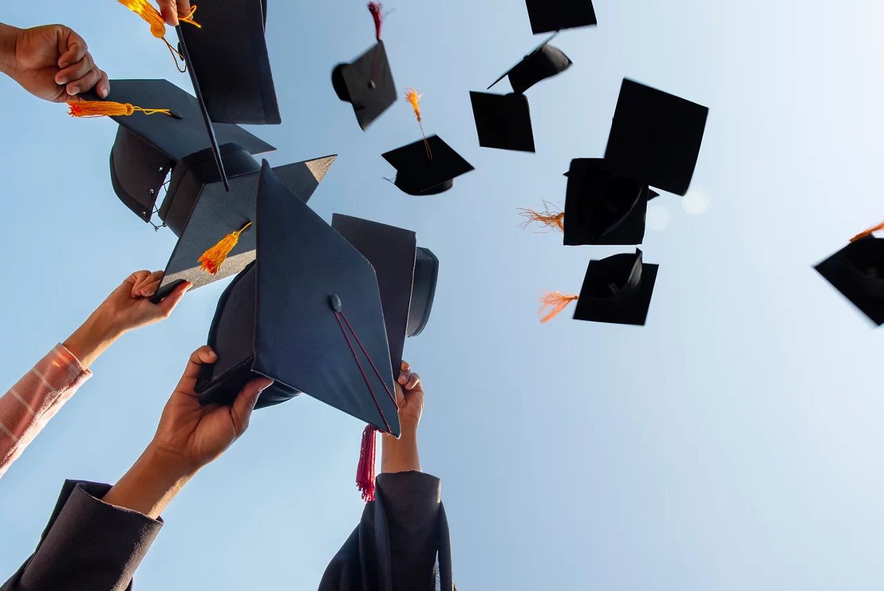 Black hat of the graduates floating in the sky.