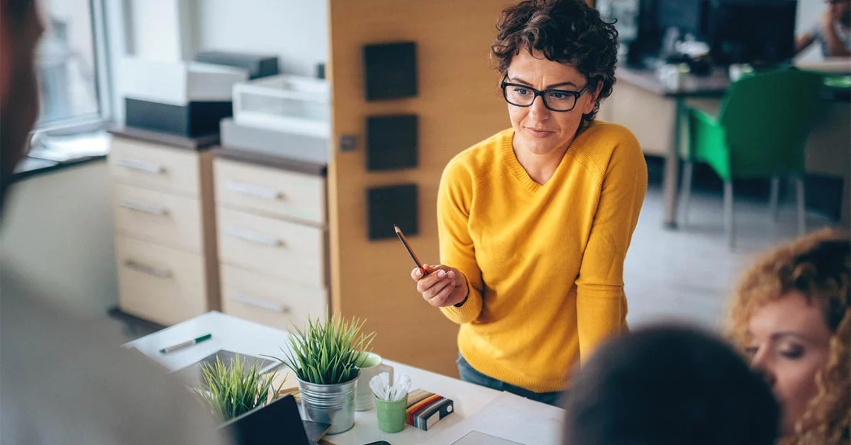 A woman is addressing her colleagues in an office
