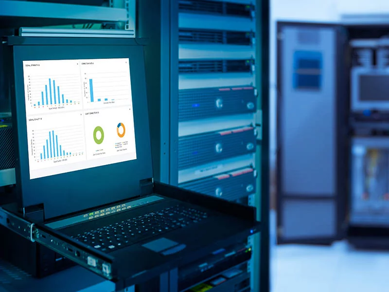 A laptop rests on a table in a server room