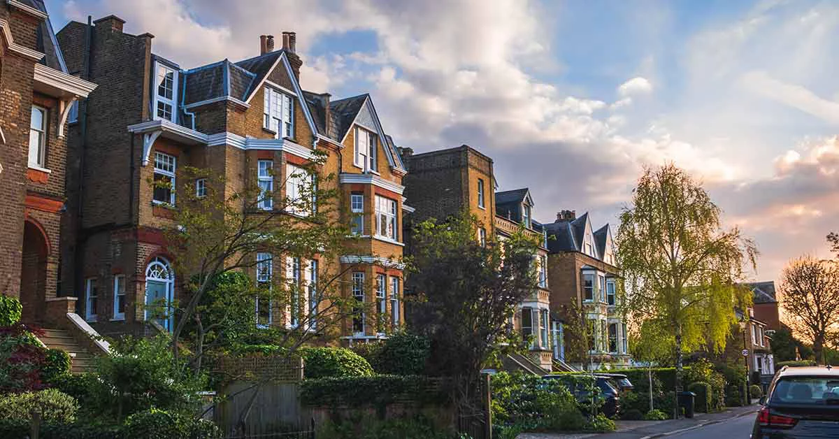 A scenic view of a row of quaint houses in the UK, featuring distinct architectural styles and well-maintained facades.