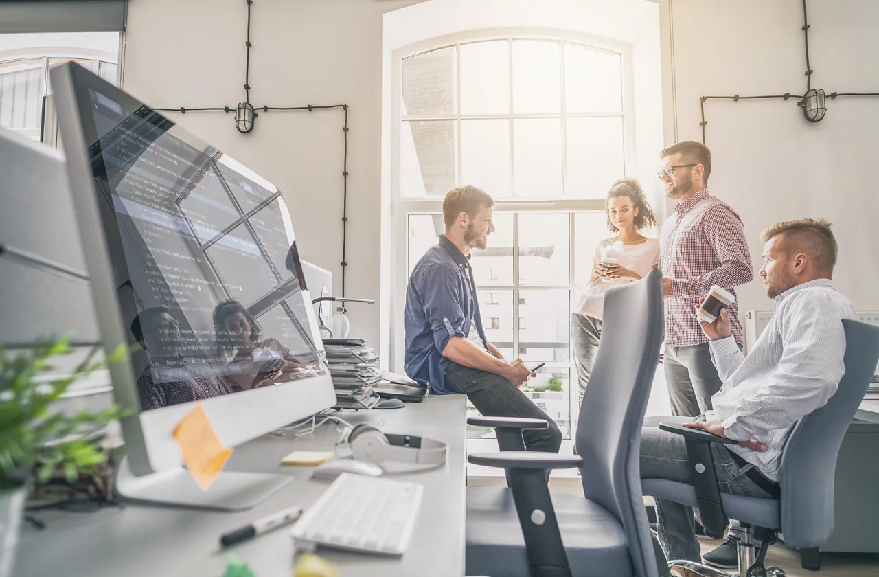 Employees having coffee and discussing something in office