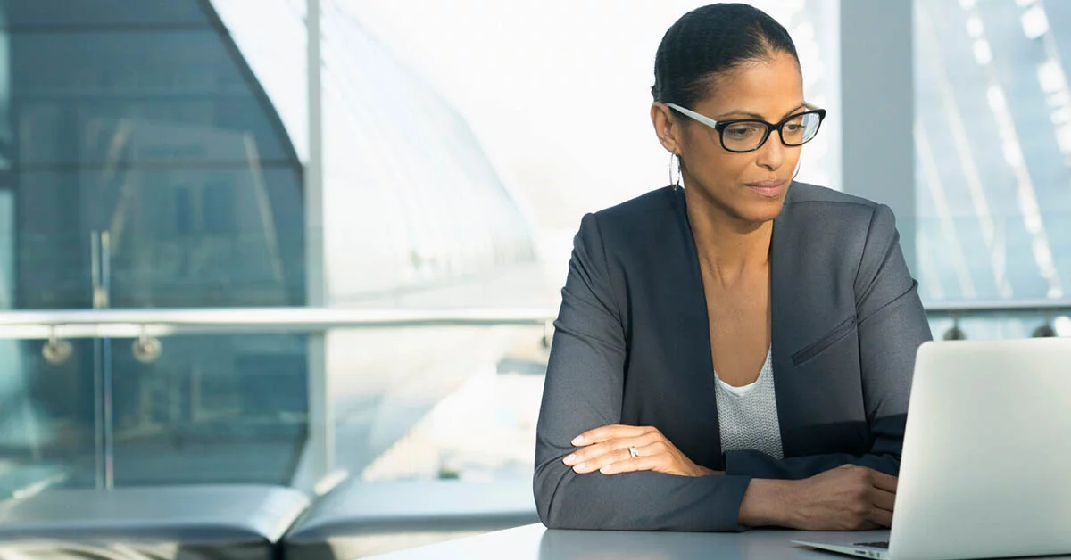 A woman wearing glasses sits at a table