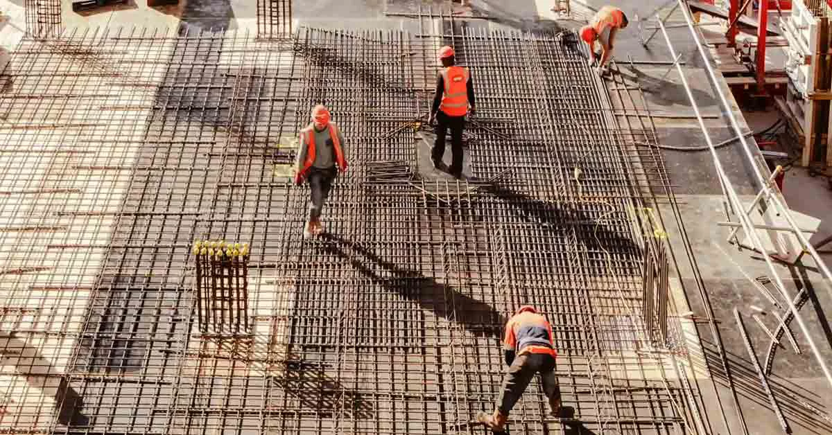 A team of construction workers applying concrete to a floor