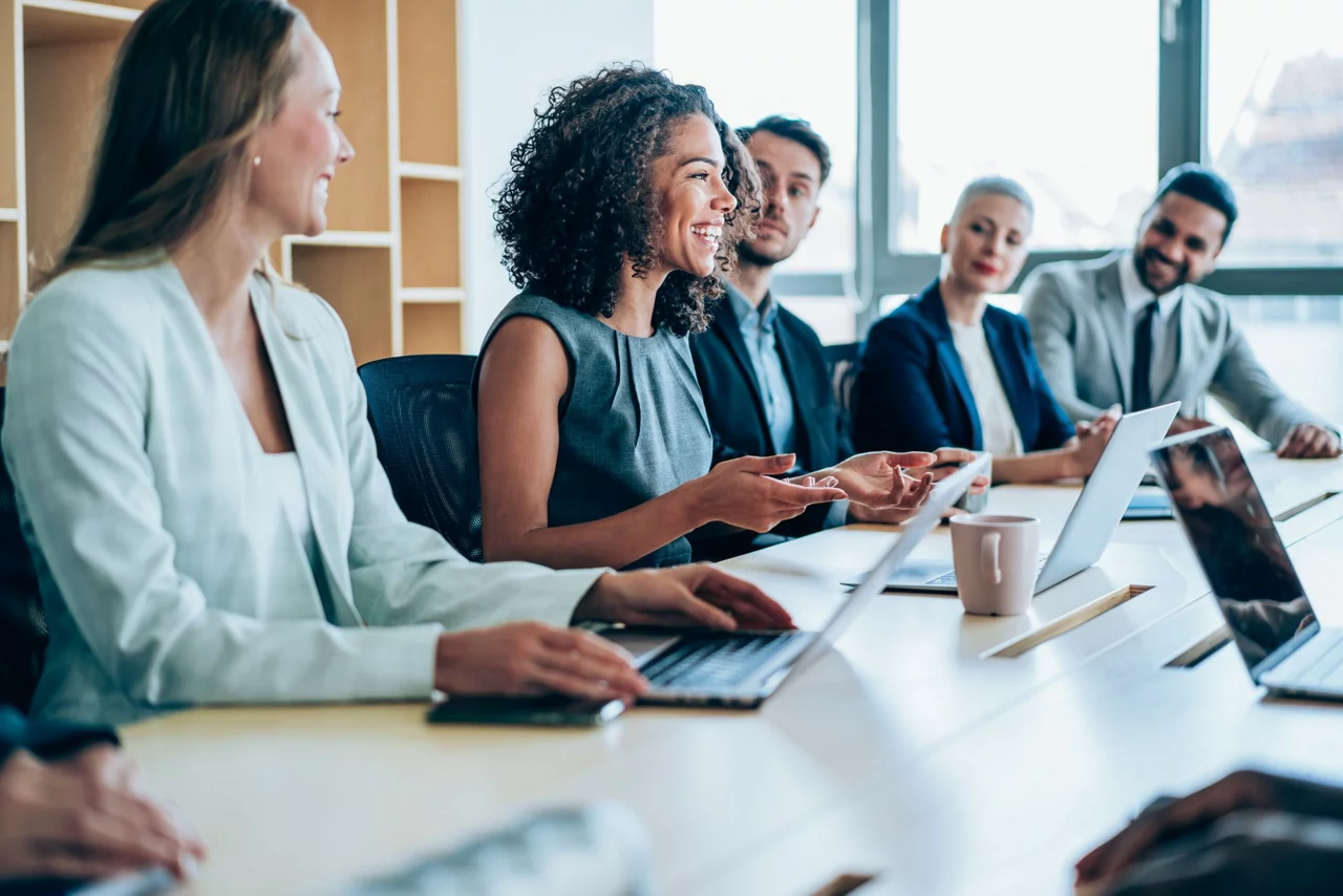 Employees smiling and working on laptop
