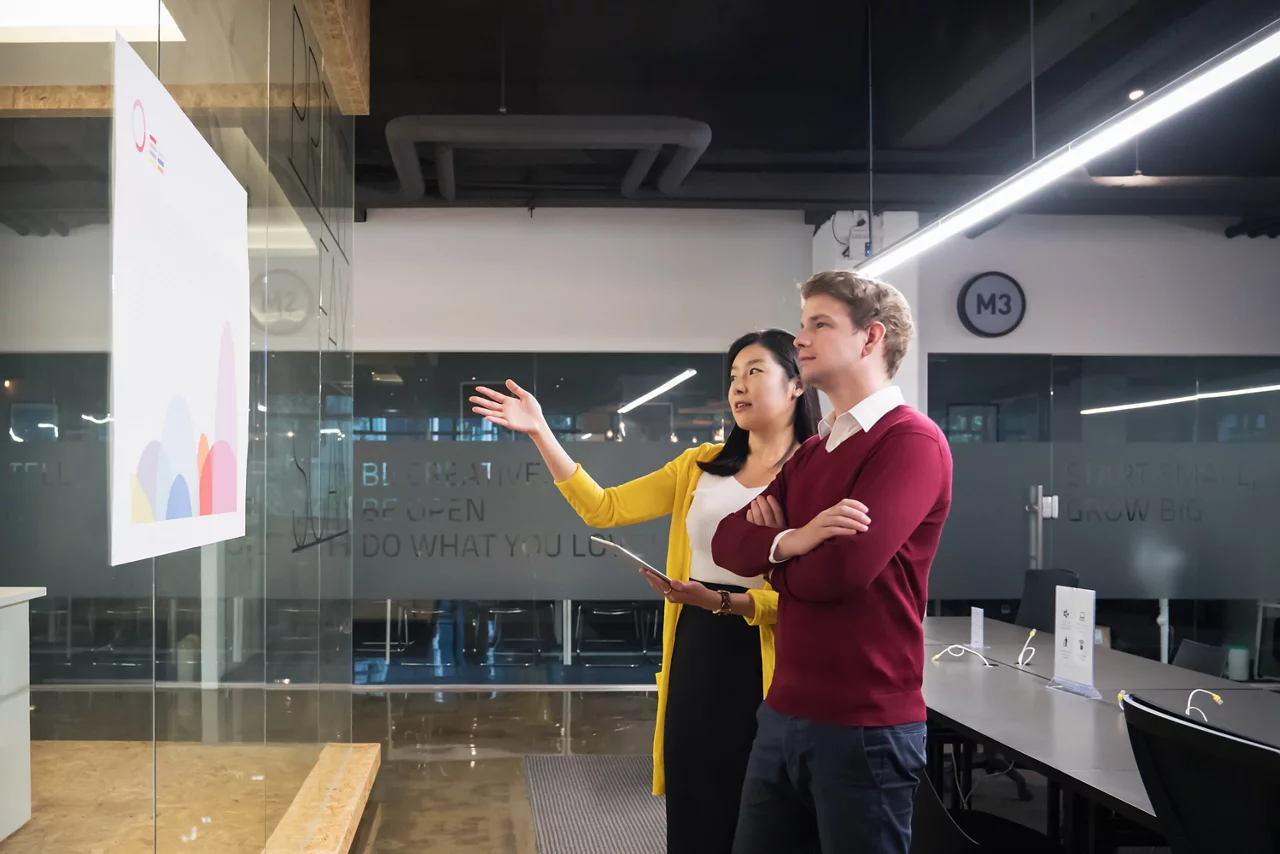 Two businessmen talking about a project in modern office.