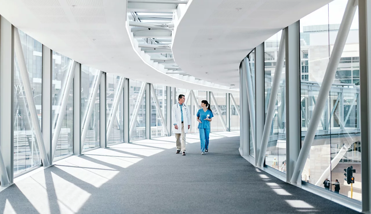 A Doctor and nurse discuss something while walking