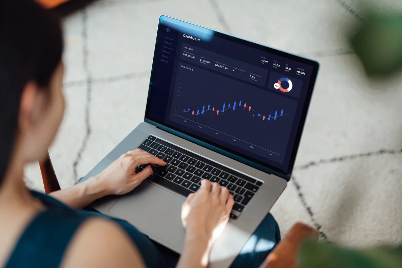 Woman trading stocks, cryptocurrency and managing financial investment on laptop