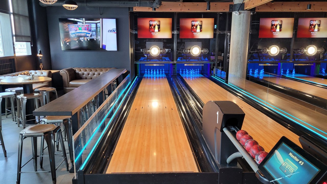 A bowling alley scene with glowing green lights and polished lanes, creating an energetic environment for players.