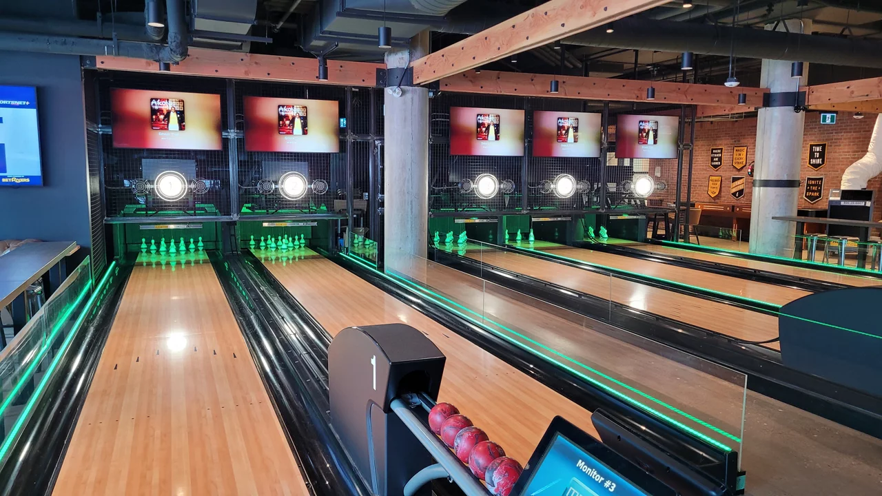 A bowling alley scene with glowing green lights and polished lanes, creating an energetic environment for players.