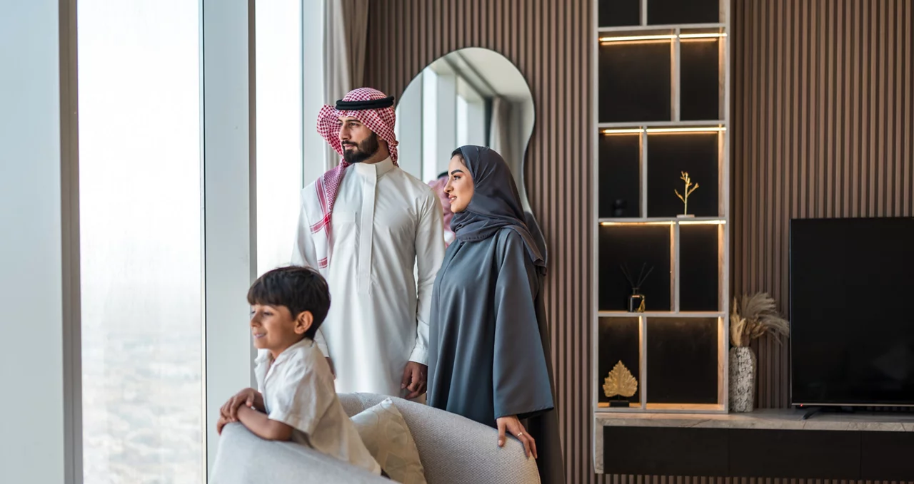 عائلة عربية مبتهجة تستمتع بمنظر أفق الرياض من منزل حديث